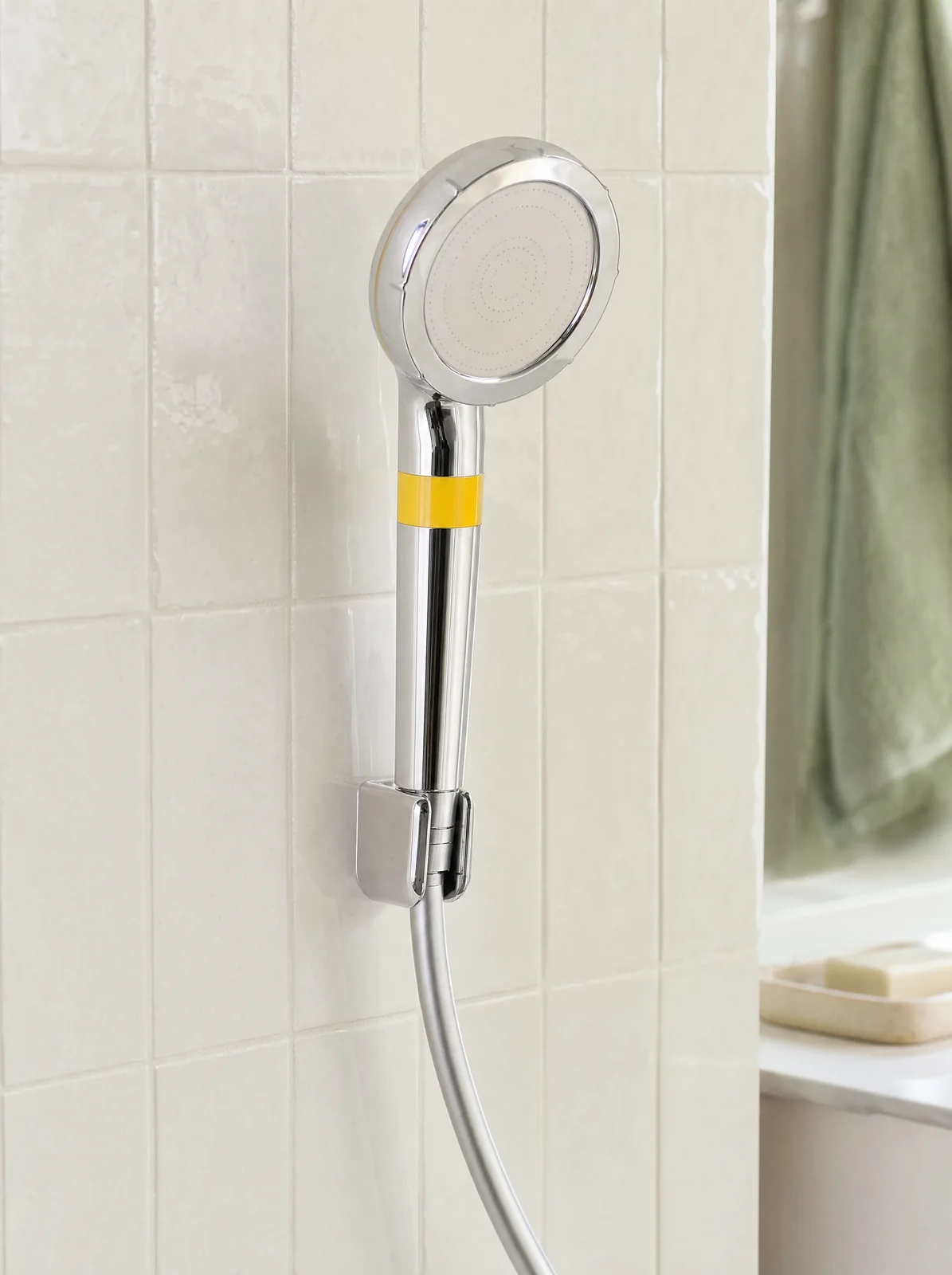 The shower head seated in a wall holder on white tile (hose and holder not included)